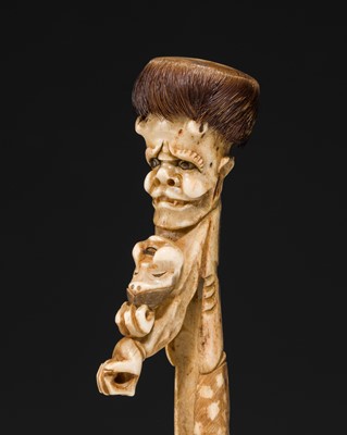 Lot 76 - AN ANTLER KISERUZUTSU (PIPE CASE) OF AN ONI WITH AN OKAME MASK
