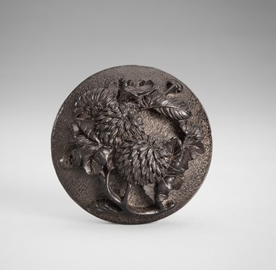 Lot 1734 - A BLACK LACQUERED WOOD MANJU NETSUKE DEPICTING A CHRYSANTHEMUM