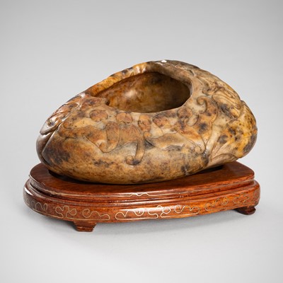 Lot 958 - A PALE CELADON AND RUSSET SOAPSTONE ‘BATS AND PEACH’ BRUSH WASHER, QING DYNASTY