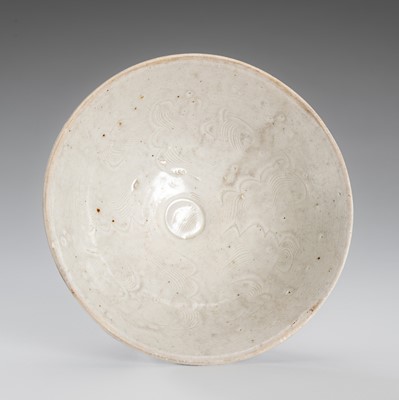 Lot 1082 - A CARVED QINGBAI ‘CLOUD SCROLL’ PORCELAIN BOWL, NORTHERN SONG DYNASTY