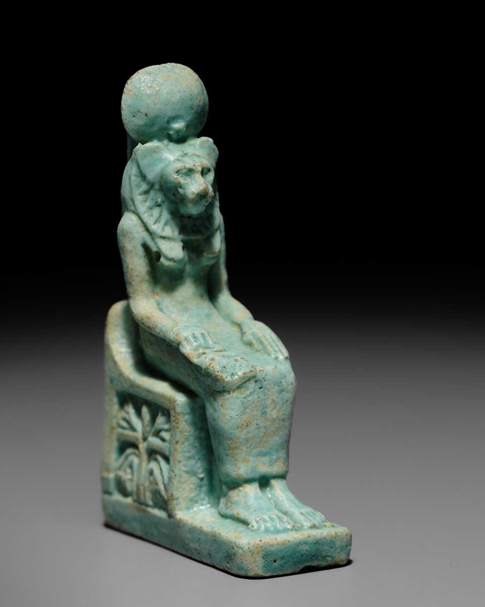 A LARGE TURQUOISE-GLAZED FAIENCE AMULET OF THE ENTHRONED SEKHMET, LATE PERIOD