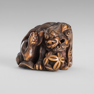 Lot 404 - MASAMITSU: A WOOD NETSUKE OF A SHISHI WITH CUB AND BALL