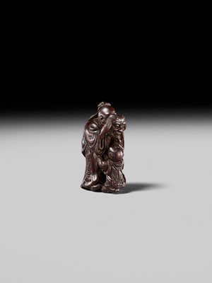 Lot 132 - HIDEMASA: A WOOD NETSUKE DEPICTING A CHINESE MAN SCARING A KARAKO