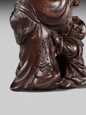 Lot 132 - HIDEMASA: A WOOD NETSUKE DEPICTING A CHINESE MAN SCARING A KARAKO