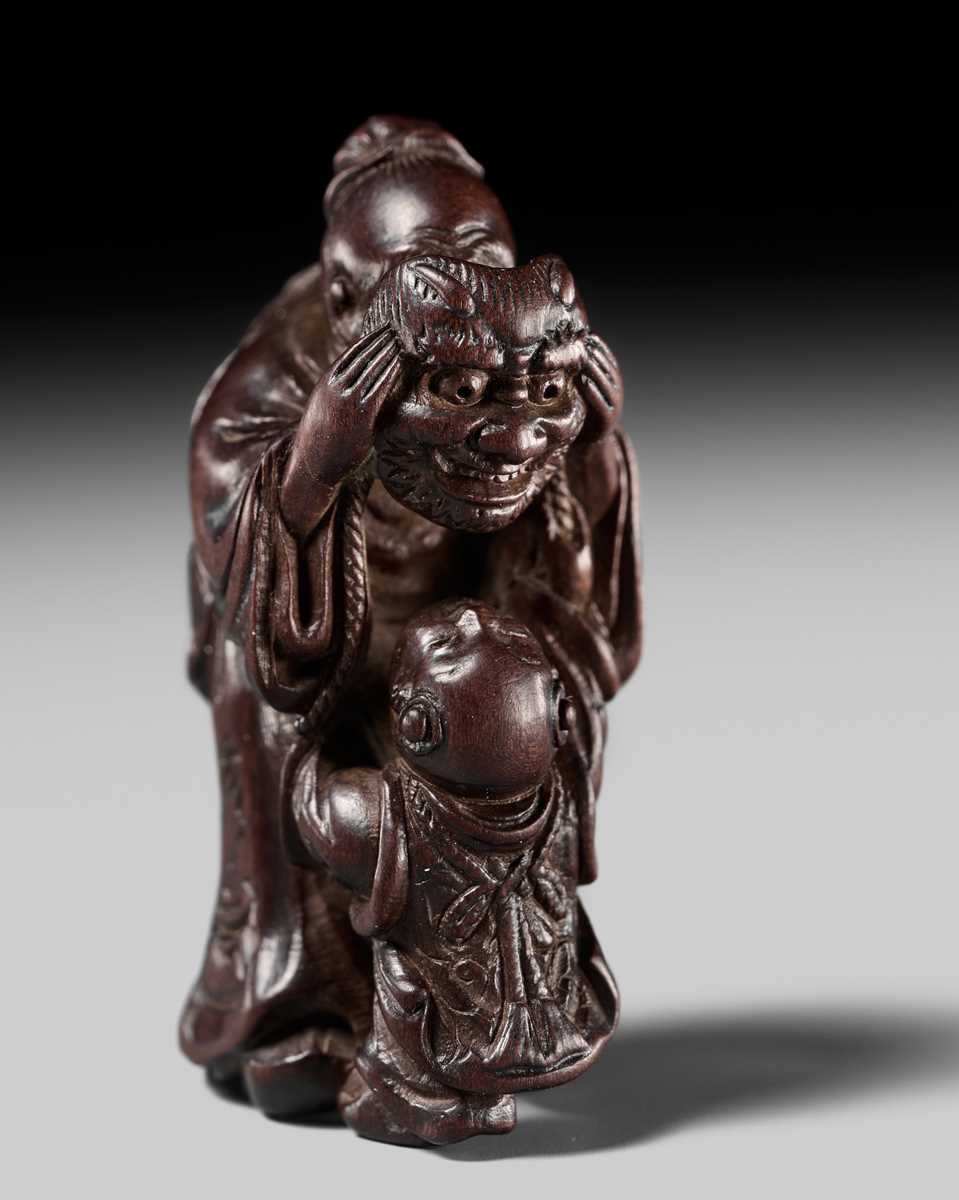 Lot 132 - HIDEMASA: A WOOD NETSUKE DEPICTING A CHINESE MAN SCARING A KARAKO