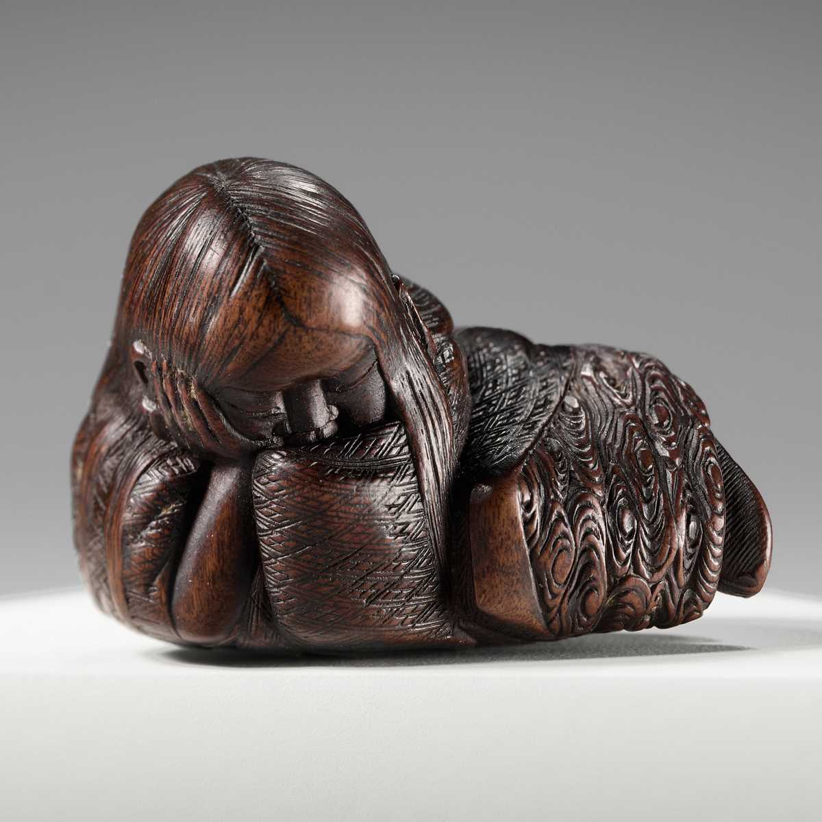 Lot 174 - ICHIUN: A WOOD NETSUKE OF A SLEEPING SHOJO