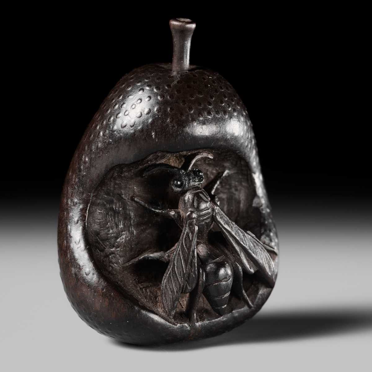 SANGETSU: A RARE EBONY WOOD NETSUKE OF A WASP IN A PEAR