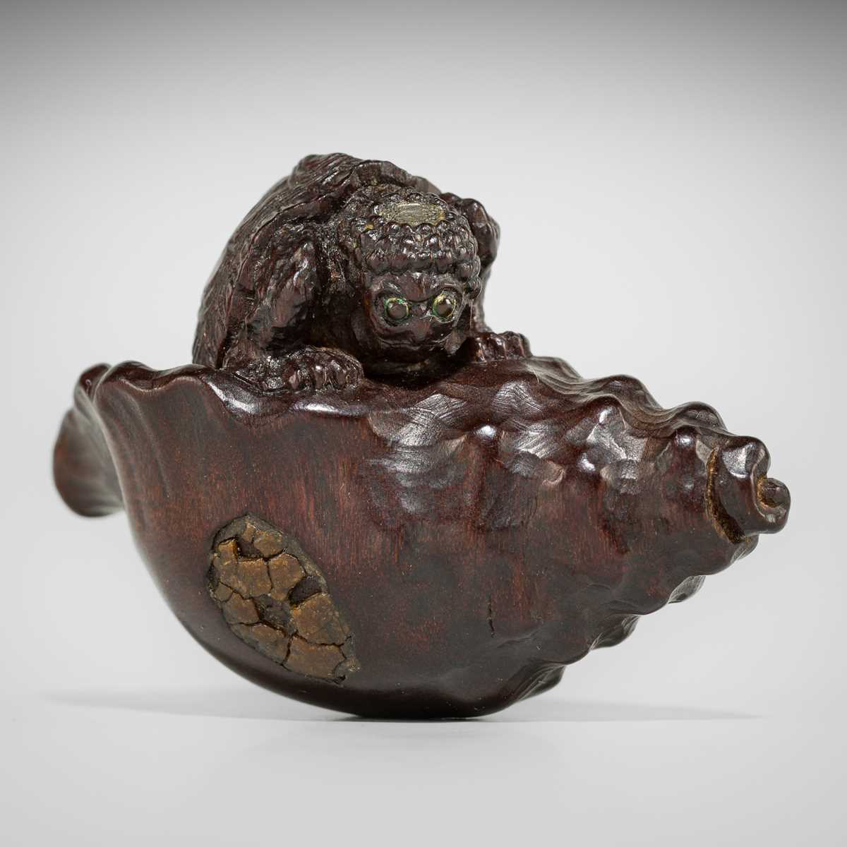Lot 433 - KOMIN: A DARK WOOD NETSUKE OF A KAPPA EMERGING FROM A CONCH