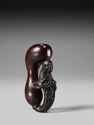 AN UNUSUAL WOOD NETSUKE OF TEKKAI SENNIN EMERGING FROM A HYOTAN (DOUBLE GOURD)