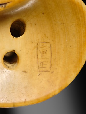 AN IVORY NETSUKE OF A FISHERGIRL (AMA) ON A LARGE CLAM