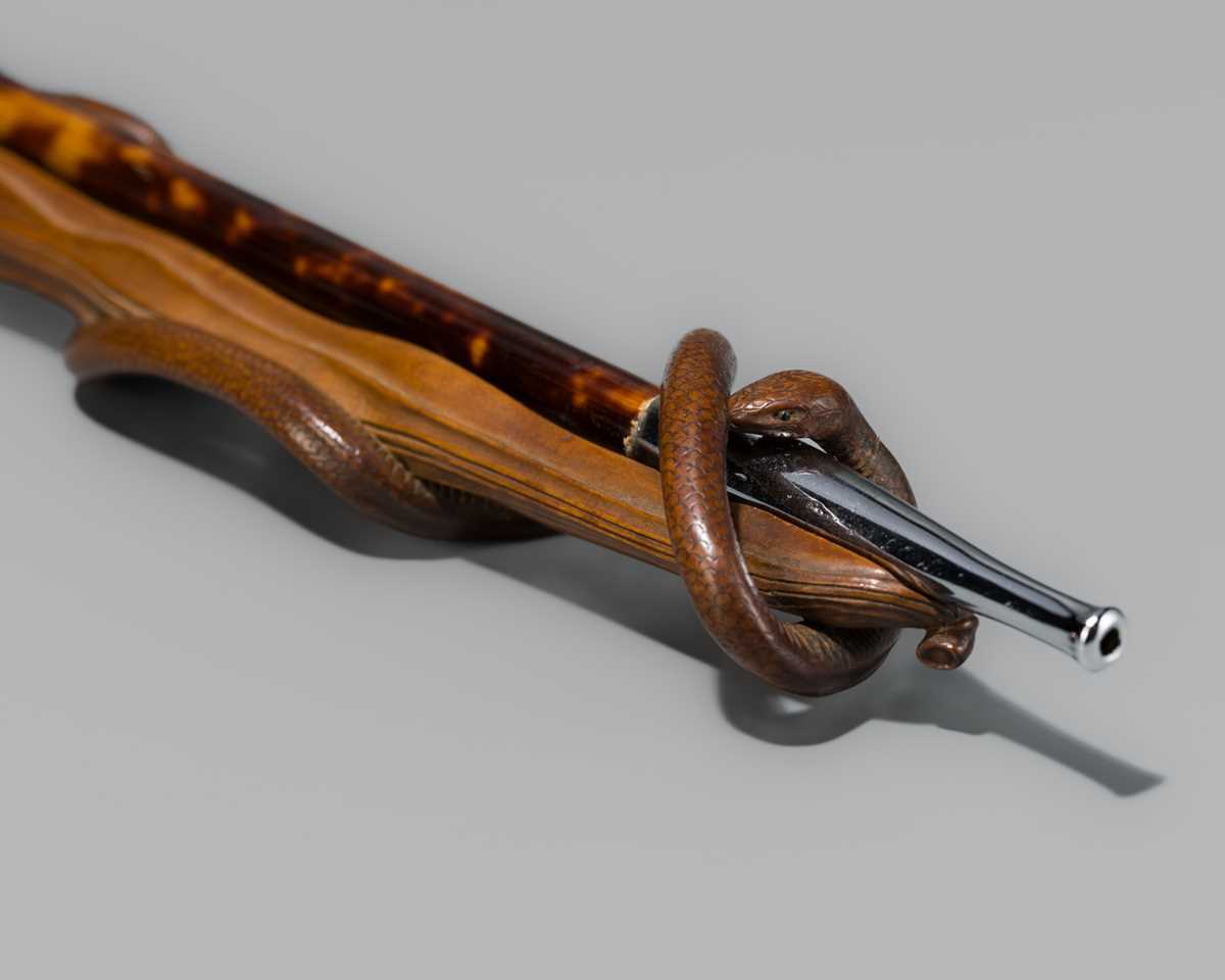Lot 69 - A FINE WOOD KISERUZUTSU (PIPE CASE) OF A SNAKE ENCIRCLING AN EDAMAME BEAN POD, WITH A MATCHING ‘TORTOISESHELL’ KISERU (PIPE)