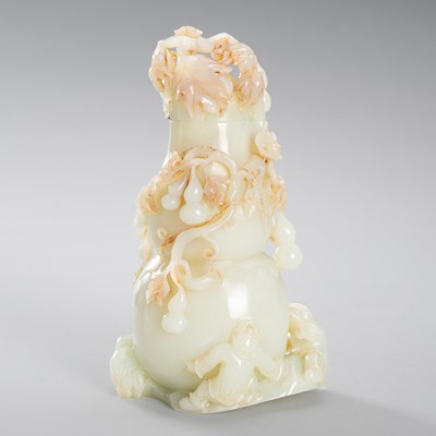 Lot 973 - A PALE CELADON AND RUSSET JADE ‘DOUBLE GOURD AND BOYS’ VASE, c. 1900s