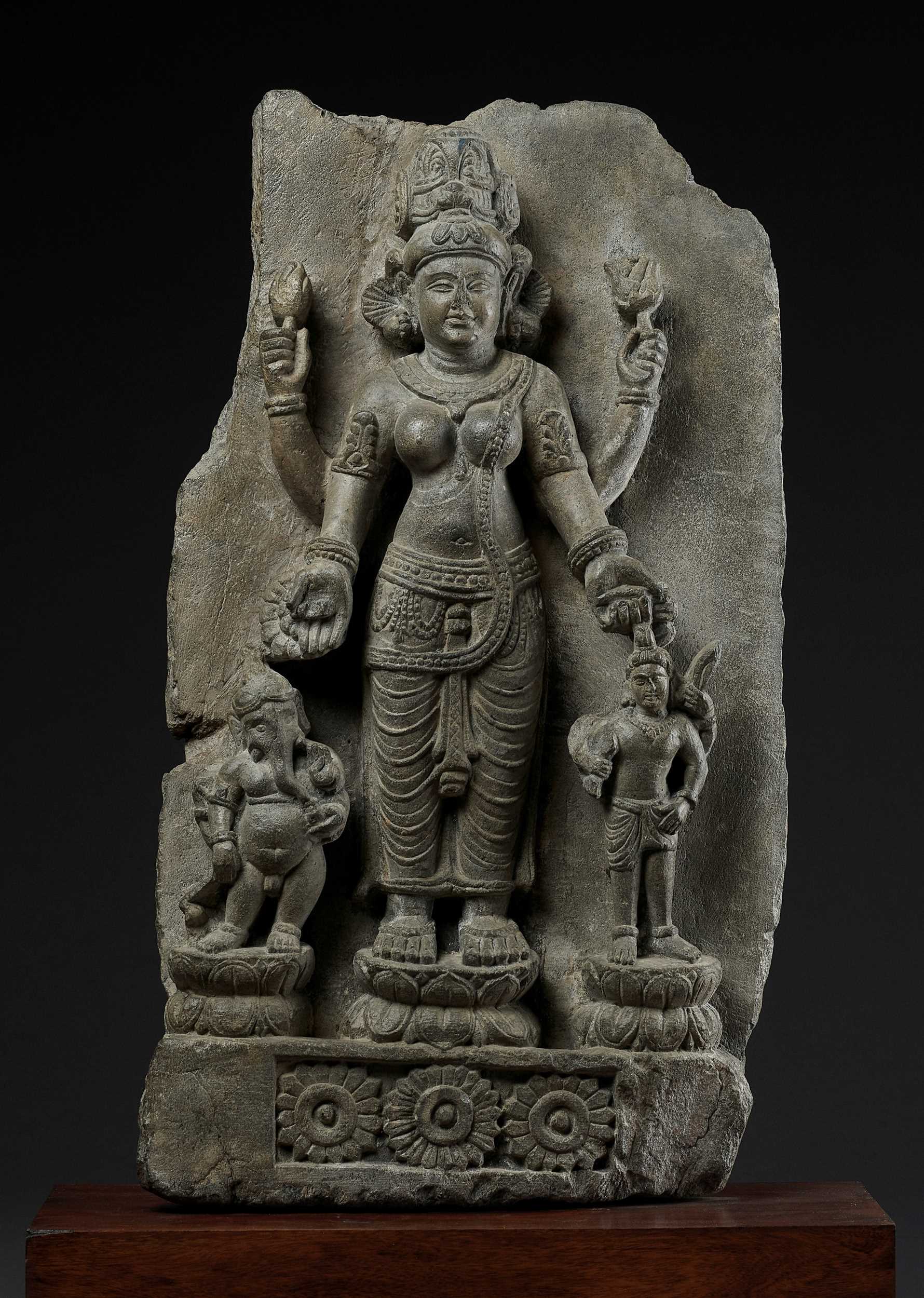 Lot 691 - AN IMPORTANT STONE STELE OF PARVATI WITH HER SONS GANESHA AND SKANDA