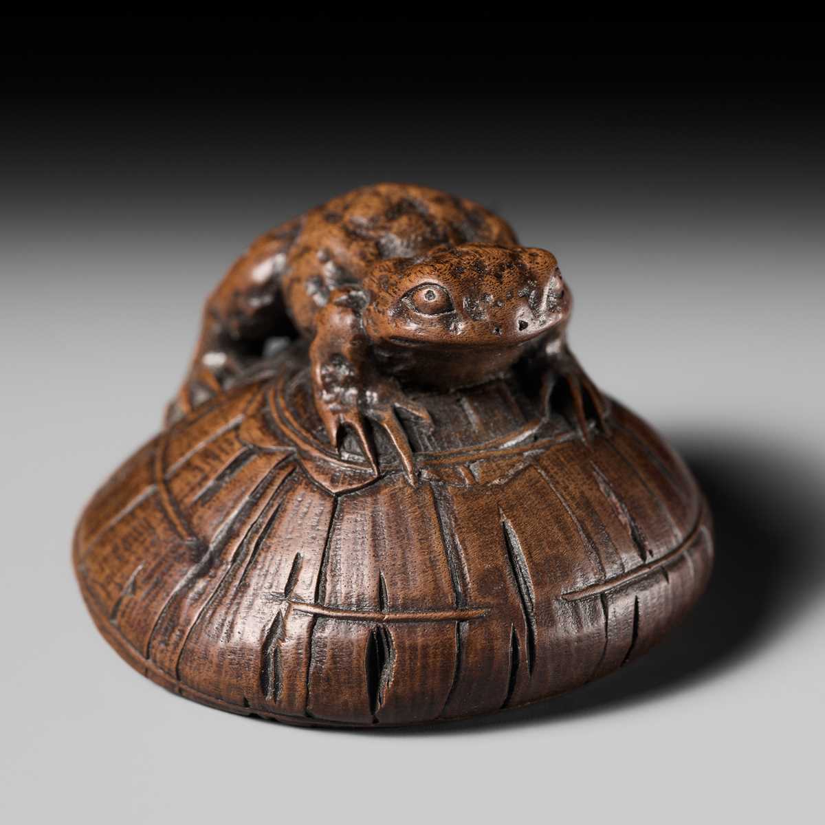 Lot 188 - ICHIMIN: A FINE NAGOYA SCHOOL WOOD NETSUKE OF A TOAD ON A KASA HAT