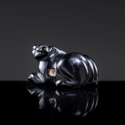 Lot 23 - A BLACK GIT BEAD IN THE FORM OF A RECUMBENT LION, HAN DYNASTY