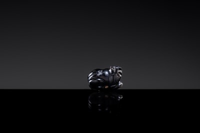 Lot 23 - A BLACK GIT BEAD IN THE FORM OF A RECUMBENT LION, HAN DYNASTY