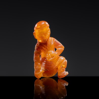 Lot 29 - A MINIATURE AMBER PENDANT IN THE FORM OF A CHARIOTEER, YUAN DYNASTY