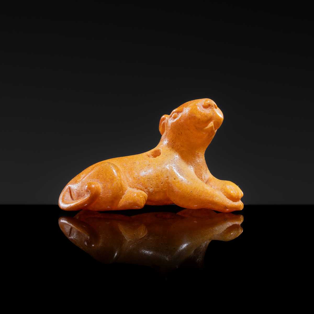 Lot 28 - A SMALL AND RARE AMBER PENDANT IN THE FORM OF A RECLINING TIGER, LIAO DYNASTY