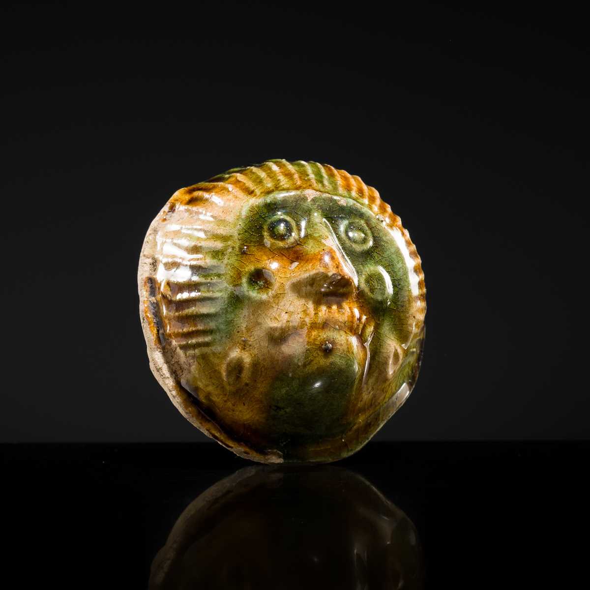 Lot 47 - A SANCAI GLAZED POTTERY ‘MASK’ WHISTLE, TANG DYNASTY