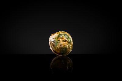 Lot 47 - A SANCAI GLAZED POTTERY ‘MASK’ WHISTLE, TANG DYNASTY