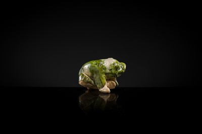 Lot 43 - A GREEN AND WHITE GLAZED POTTERY FIGURE OF A LION SCRATCHING ITSELF, TANG DYNASTY