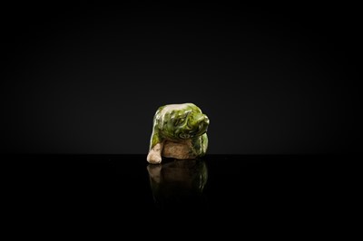 Lot 43 - A GREEN AND WHITE GLAZED POTTERY FIGURE OF A LION SCRATCHING ITSELF, TANG DYNASTY
