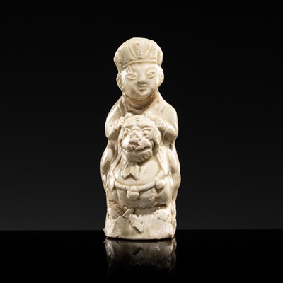 Lot 74 - A SMALL WHITE GLAZED DINGYAO FIGURE OF A BOY RIDING A BUDDHIST LION, NORTHERN SONG DYNASTY