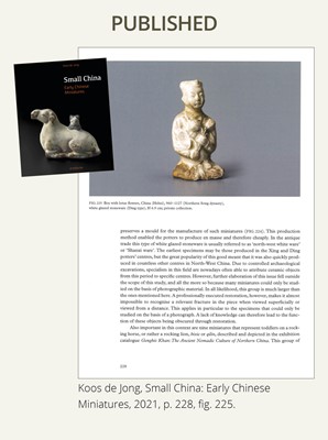 A SMALL WHITE GLAZED DINGYAO FIGURE OF A SEATED BOY WITH LOTUS FLOWERS, NORTHERN SONG DYNASTY