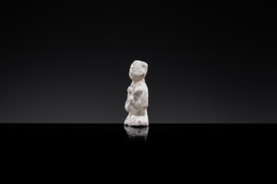 A SMALL WHITE GLAZED DINGYAO FIGURE OF A SEATED BOY WITH LOTUS FLOWERS, NORTHERN SONG DYNASTY