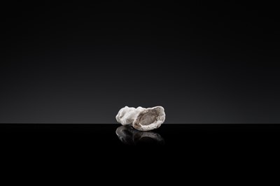 A SMALL WHITE GLAZED DINGYAO FIGURE OF A SEATED BOY WITH LOTUS FLOWERS, NORTHERN SONG DYNASTY