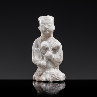 Lot 75 - A SMALL WHITE GLAZED DINGYAO FIGURE OF A SEATED BOY WITH LOTUS FLOWERS, NORTHERN SONG DYNASTY