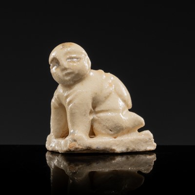 Lot 89 - A WHITE GLAZED DINGYAO MINIATURE FIGURE OF A CRAWLING TODDLER (HEJI), NORTHERN SONG DYNASTY