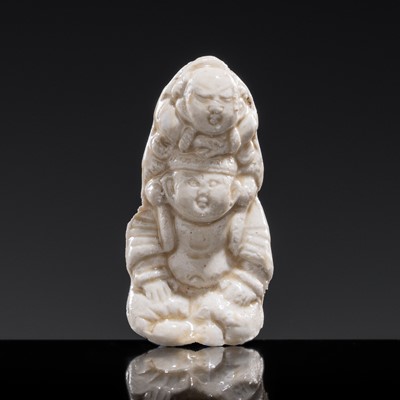 Lot 85 - A SMALL WHITE GLAZED DINGYAO FIGURE OF A BOY CARRYING A TODDLER, NORTHERN SONG DYNASTY