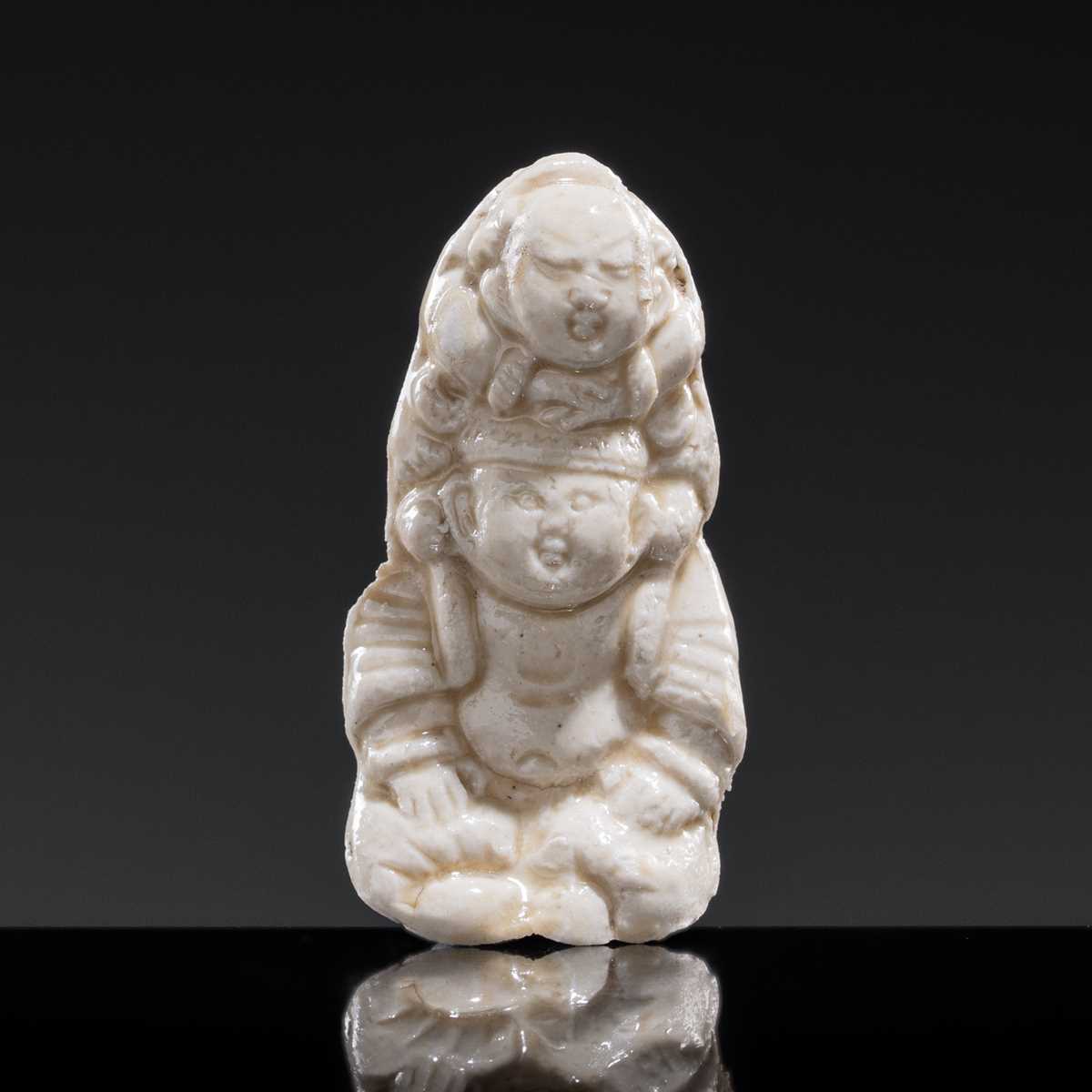 Lot 85 - A SMALL WHITE GLAZED DINGYAO FIGURE OF A BOY CARRYING A TODDLER, NORTHERN SONG DYNASTY