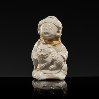 Lot 76 - A SMALL WHITE GLAZED DINGYAO FIGURE OF A BOY WITH A BUDDHIST LION, NORTHERN SONG DYNASTY