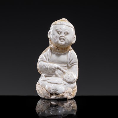 Lot 82 - A SMALL WHITE GLAZED DINGYAO FIGURE OF A SEATED GIRL HOLDING A DOLLHEAD, NORTHERN SONG DYNASTY