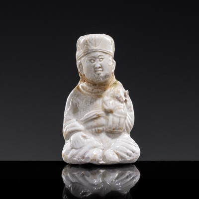 A SMALL WHITE GLAZED DINGYAO FIGURE OF A SEATED BOY HOLDING A DOLL, NORTHERN SONG DYNASTY
