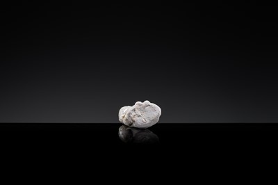 A SMALL WHITE GLAZED DINGYAO FIGURE OF A SEATED BOY HOLDING A DOLL, NORTHERN SONG DYNASTY