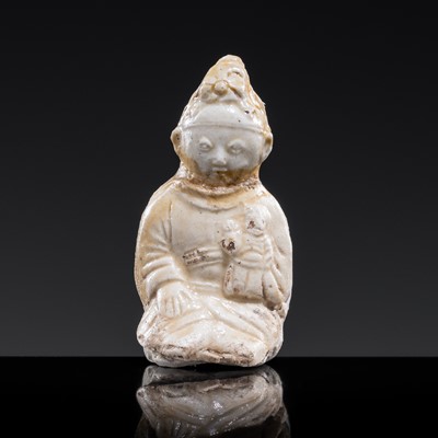 Lot 59 - A SMALL WHITE GLAZED DINGYAO FIGURE OF A SEATED GIRL HOLDING A DOLL, EARLY SONG TO EARLY LIAO DYNASTY