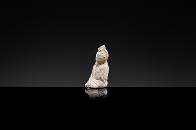 Lot 59 - A SMALL WHITE GLAZED DINGYAO FIGURE OF A SEATED GIRL HOLDING A DOLL, EARLY SONG TO EARLY LIAO DYNASTY