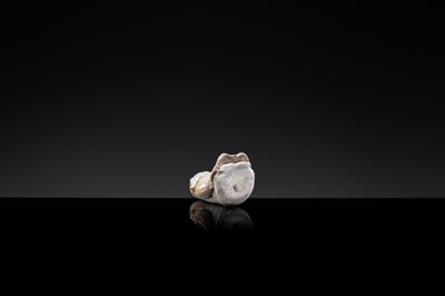 Lot 59 - A SMALL WHITE GLAZED DINGYAO FIGURE OF A SEATED GIRL HOLDING A DOLL, EARLY SONG TO EARLY LIAO DYNASTY