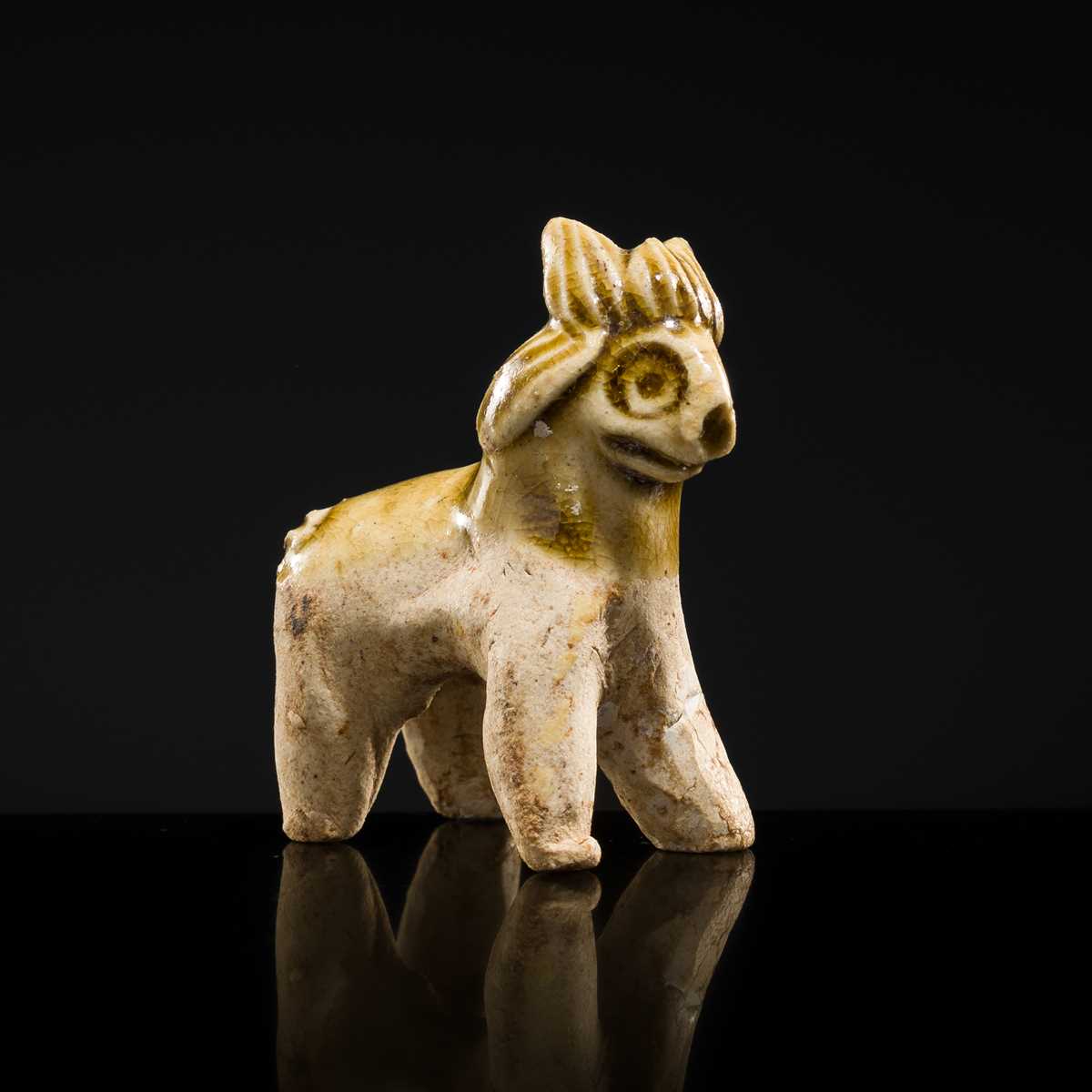 Lot 65 - A MOTTLED YELLOWISH-WHITE GLAZED MINIATURE FIGURE OF A GOAT, SONG DYNASTY