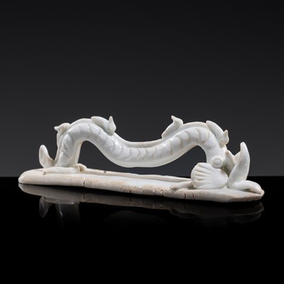 Lot 71 - A QINGBAI GLAZED PORCELAIN BRUSH REST IN THE FORM OF A WINDING DRAGON, SONG DYNASTY