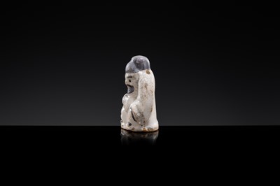 A WHITE AND DARK BROWN GLAZED STONEWARE FIGURE OF AN OFFICIAL, YUAN DYNASTY