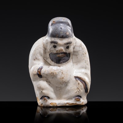 Lot 123 - A WHITE AND DARK BROWN GLAZED STONEWARE FIGURE OF AN OFFICIAL, YUAN DYNASTY
