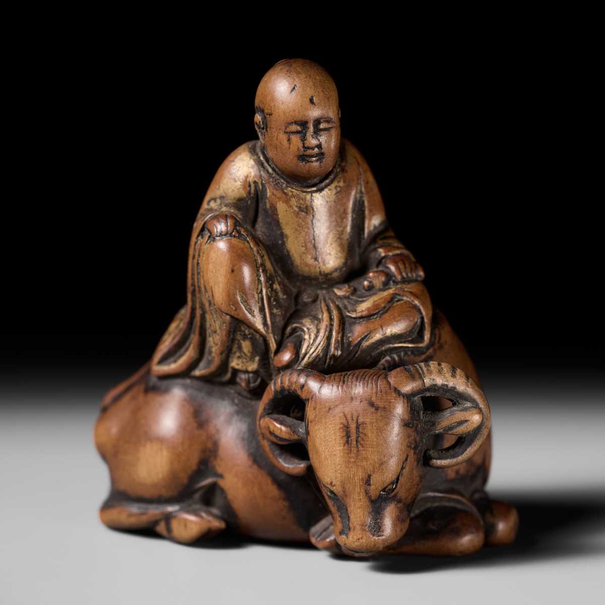 Lot 84 - A SUPERB AND EARLY WOOD NETSUKE OF ROSHI SEATED ON HIS OX