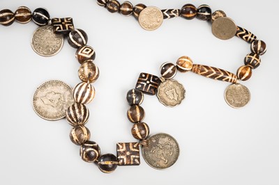 Lot 1344 - AN EXCEPTIONAL NECKLACE OF PUMTEK PETRIFIED WOOD BEADS AND COINS, c. 10TH CENTURY
