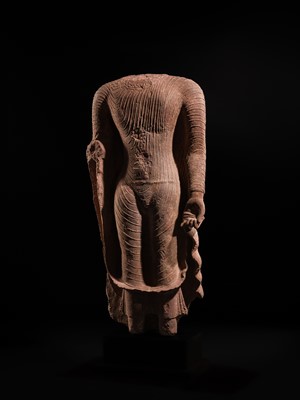 AN ICONIC RED SANDSTONE TORSO OF THE BUDDHA, GUPTA PERIOD, MATHURA, 3RD-5TH CENTURY