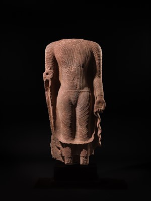 AN ICONIC RED SANDSTONE TORSO OF THE BUDDHA, GUPTA PERIOD, MATHURA, 3RD-5TH CENTURY