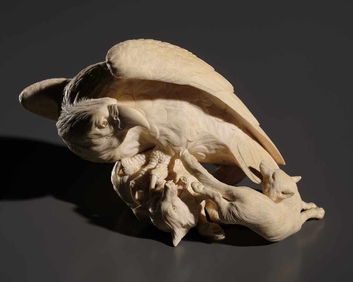 TOMOKAZU: A SUPERB IVORY OKIMONO OF AN EAGLE WITH TWO FOXES